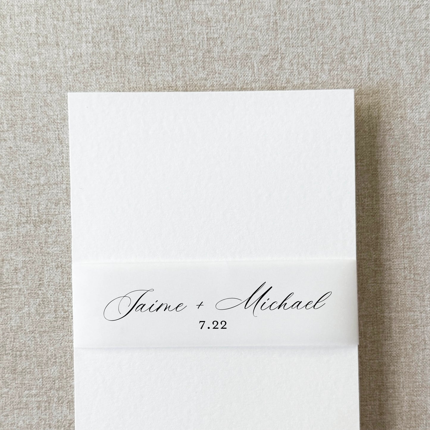 Custom wedding belly band in modern script wrapped around an invitation suite